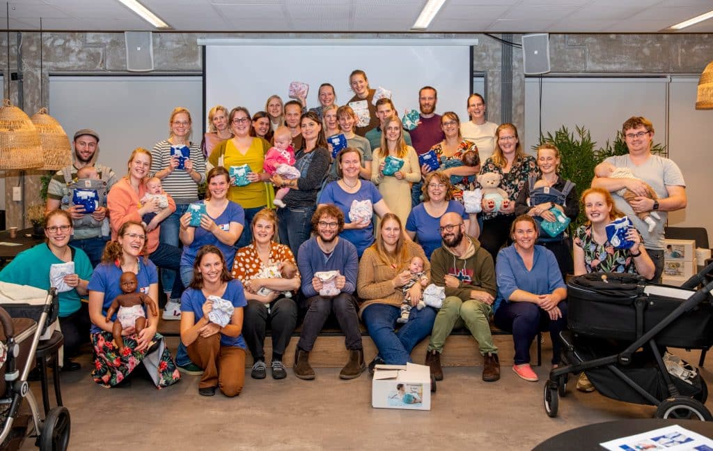 Grote groep jonge ouders met hun baby's die poseren voor de foto